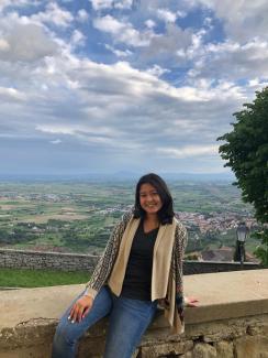 Jamie in front of a scenic Italian landscape.