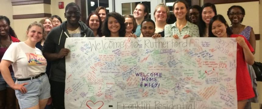 FRC Members stand with welcome sign in Rutherford Hall